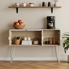 Wooden console table with coffee maker, apples, and jars against a beige wall.