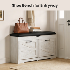 White shoe bench with black cushion in an entryway, featuring a brown handbag and books.